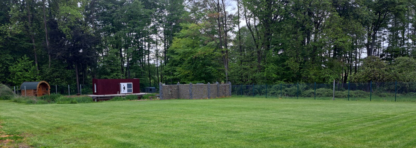 Wellness-Oase mit Sauna, Teich, kleinem Bungalow und großer Wiese.